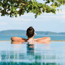 Vitalträume die Rückseite einer Frau, die sich in einem wahrscheinlichen Pool bei schönem Wetter entspannt